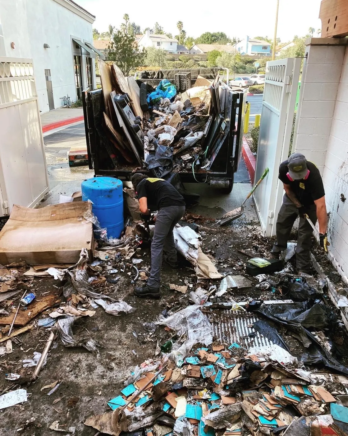 Team clearing debris from a narrow side yard